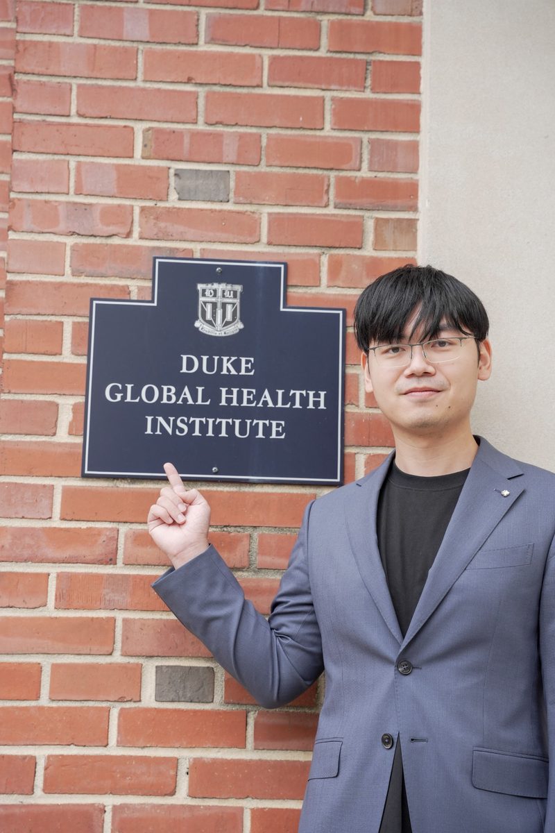 Ni standing beside the Duke Global Health Institute sign.
